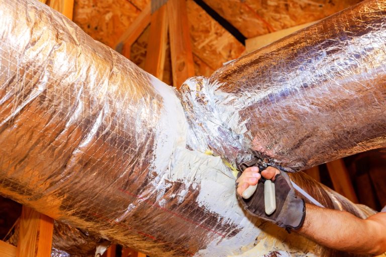 HVAC technician sealing a duct